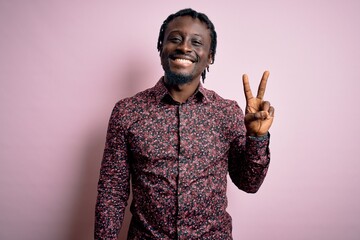 Wall Mural - Young handsome african american man wearing casual shirt standing over pink background showing and pointing up with fingers number two while smiling confident and happy.