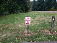Red And White No Parking Any Time On Grass Sign