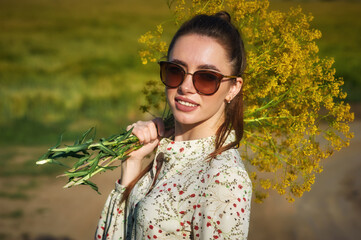 Portrait of a young beautiful woman in a summer dress in nature