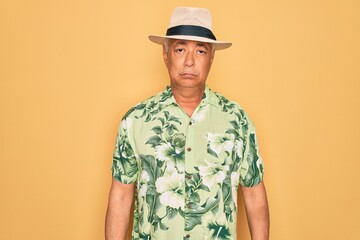 Wall Mural - Middle age senior grey-haired man wearing summer hat and floral shirt on beach vacation depressed and worry for distress, crying angry and afraid. Sad expression.