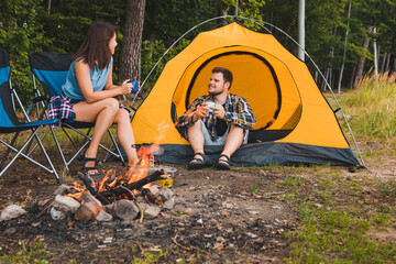 Wall Mural - couple sitting at camping site talking drinking hot tea