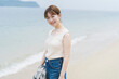 © peach100 - 海辺を散策する女性