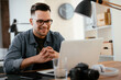 © JustLife - Young businessman using laptop in his office. Businessman working and taking notes.