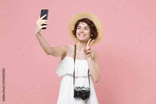 Fotografía Smiling tourist girl in dress hat photo camera isolated on pink background