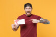 © ViDi Studio - Excited young bearded tattooed man guy in casual t-shirt black cap posing isolated on yellow background studio. People lifestyle concept. Mock up copy space. Pointing index finger on gift certificate.
