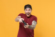© ViDi Studio - Excited young bearded tattooed man guy in casual t-shirt black cap posing isolated on yellow wall background studio portrait. People lifestyle concept. Mock up copy space. Play game with joystick.
