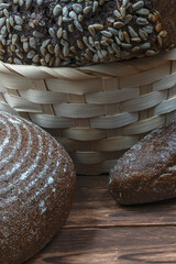 Poster - different types of wheat bread in a wicker basket and on the kitchen table