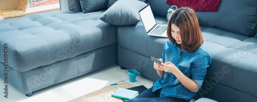 Fotografía Banner asian woman using smartphone reading online social media shopping online website on smartphone with smile face