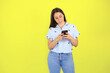 © Irene - Young beautiful woman standing over yellow isolated background smiling and chatting on the phone