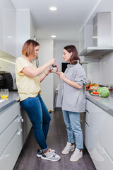 Wall Mural - Cheerful friends cooking healty food in the home kitchen