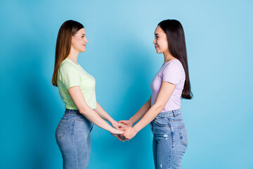 Poster - Profile photo of cheerful two lesbians couple young students best friends buddies holding arms look eyes feelings wear casual t-shirts jeans footwear isolated blue color background