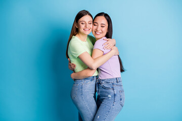 Wall Mural - Profile photo of cheerful lesbians couple hugging good mood young students best friends fellows buddies eyes closed wear casual green purple t-shirts jeans isolated blue color background