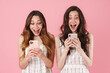 © Drobot Dean - Image of excited women expressing surprise and using cellphones