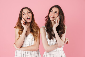 Sticker - Image of joyful caucasian women smiling and talking on cellphones