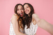 © Drobot Dean - Image of excited pretty women hugging while taking selfie photo