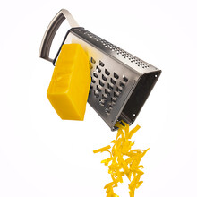 Grated Cheese Falling From Metal Grater Isolated On White Background