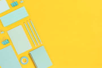 Layout of mint color school equipment on a bright yellow background. Creative concept with place for text.