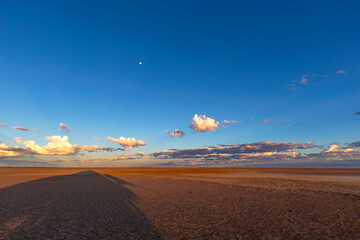 long shadows on verneukpan and clouds on the horizon