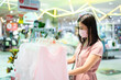 © Joeahead - An Asian woman shopping in the kid clothing store after opening lockdown with pink mask and social distancing.