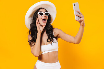 Wall Mural - Image of elegant cheerful woman taking selfie on cellphone