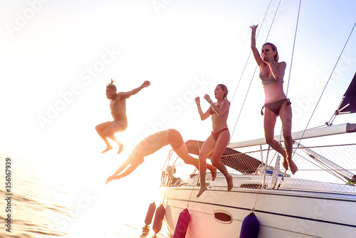 Cuadros en Lienzo Young millenial friends jumping from sailboat at sea ocean trip - Guys and girls