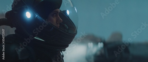 Fotografía Caucasian female astronaunt wearing a space suit exploring planet surface, night