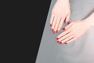 Wall Mural - Woman hands with perfect classic manicure with red polish. Minimal black and white background. Copy space for your text.