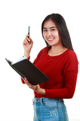 Young Asian woman holding book and taking note with smiling to camre on white background