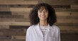 © vesperstock - CU Young Hispanic woman in white lab coat looking to camera, expressing happiness and confidence. Scientist, researcher, student or laboratory technician