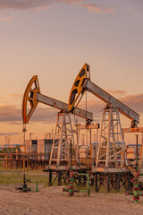 Wall Mural - Petroleum concept. Oil pump rig. Oil and gas production. Oilfield site. Pump Jack are running. Drilling derricks for fossil fuels output and crude oil production. Global crisis. War on oil prices.