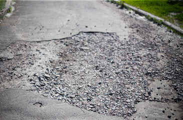 Broken asphalt and cracks on the road surface