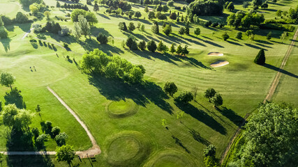 Poster - Drone view of a beautiful golf course at sunset with shadows and shapes