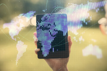 Double exposure of business theme sketch hologram and woman holding and using a mobile device.