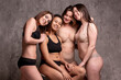 © kalinichenkod - Beautiful overweight and slim women in a beige and black swimsuit on a gray background. Body positive. Size plus.