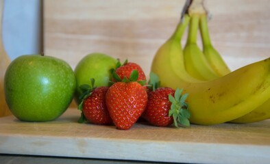 Poster - Closeup shot of fresh strawberries, bananas and apples on the table