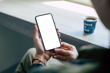 cell phone mockup image blank white screen.woman hand holding texting using mobile on desk at coffee shop.background empty space for advertise.work people contact marketing business,technology