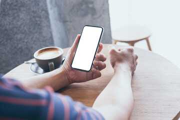 cell phone mockup image blank white screen.man hand holding texting using mobile on desk at coffee shop.background empty space for advertise.work people contact marketing business,technology