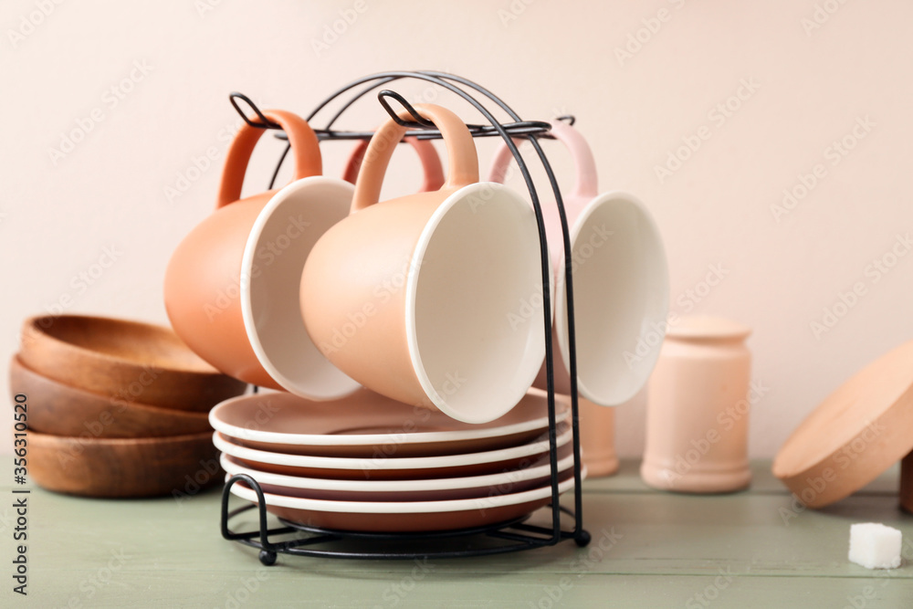 Holder with cups and saucers on kitchen table