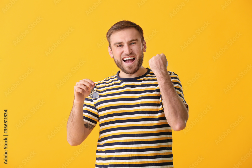 Happy young man with key on color background