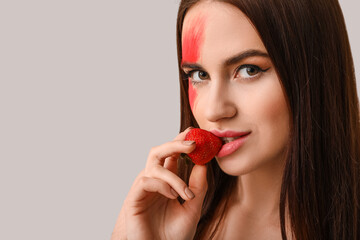 Sticker - Sexy young woman with strawberry on light background