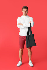 Sticker - Young man with eco bag on color background