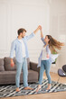 © zinkevych - Young smiling couple in denim dancing and feeling excited