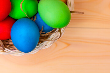 easter eggs in a wicker basket on a wooden table