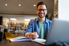 Smiling Male Student Working And Studying In A Library