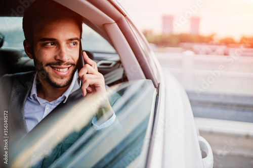 Fotografía Businessman talking on a phone and looking through the window from the car