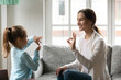 © fizkes - Smiling young Caucasian mom and little daughter make hand gesture learn speak sign language at home, happy mother or nanny practice nonverbal talk with small disabled girl child, disability concept