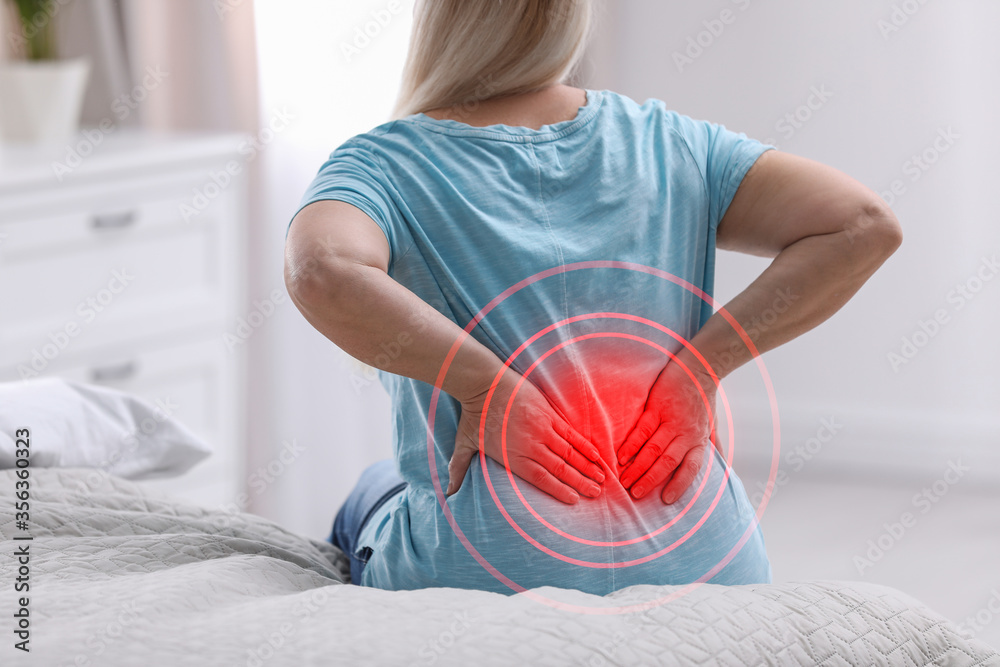 Senior woman suffering from back pain after sleeping on uncomfortable mattress at home, closeup - obrazy, fototapety, plakaty 