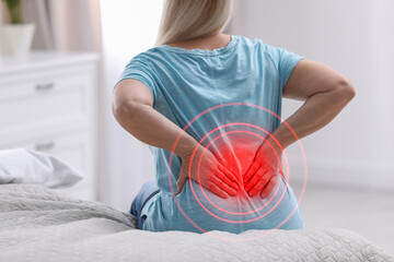 Wall Mural - Senior woman suffering from back pain after sleeping on uncomfortable mattress at home, closeup