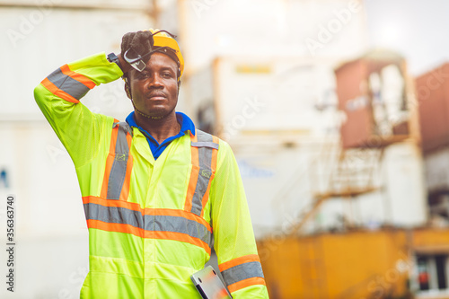 Fotomural Tired stress worker sweat from hot weather in summer working in port goods cargo shipping logistic ground, Black African race people