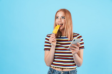 Sticker - Image of cheerful pretty girl eating ice-cream and using cellphone